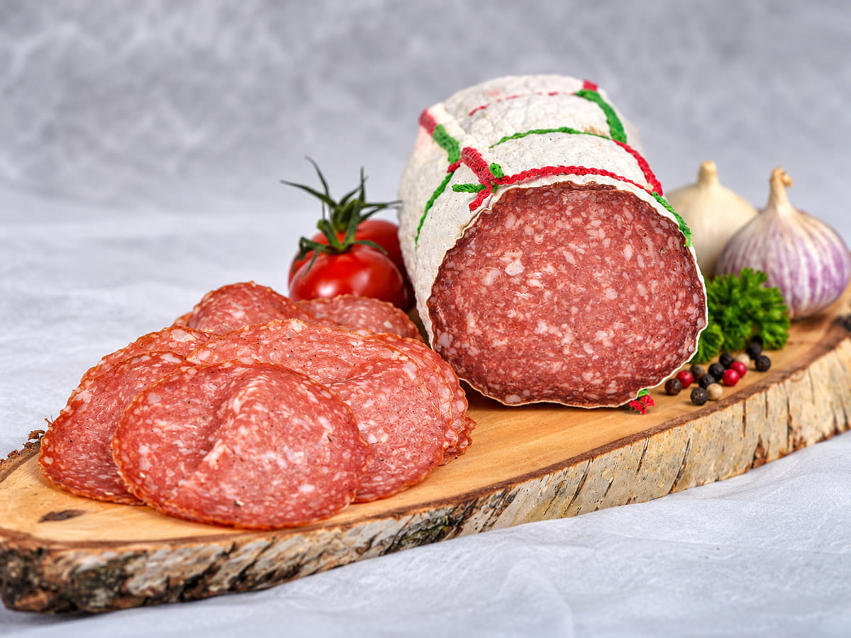 Fleischwurst im Ring, angeschnitten, auf einem Holzbrett